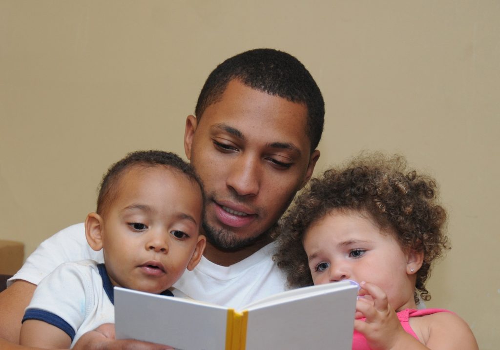 Image of father reading to two young children
