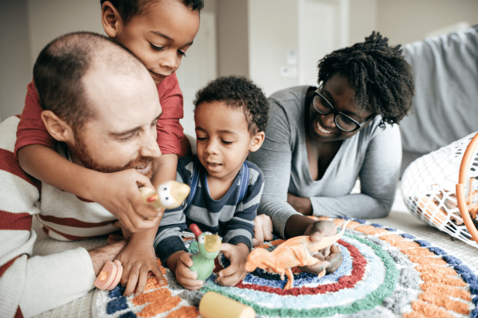 Interracial family of four playing with dinosaurs