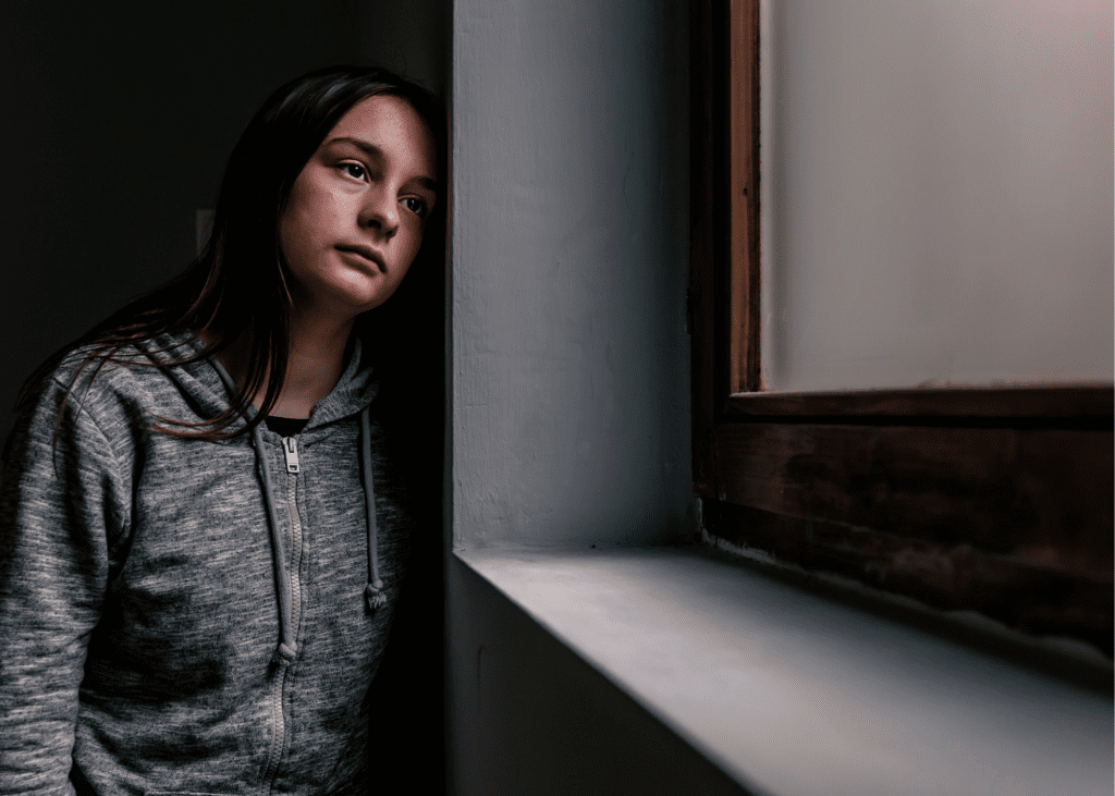Young women looking at the window with sadness